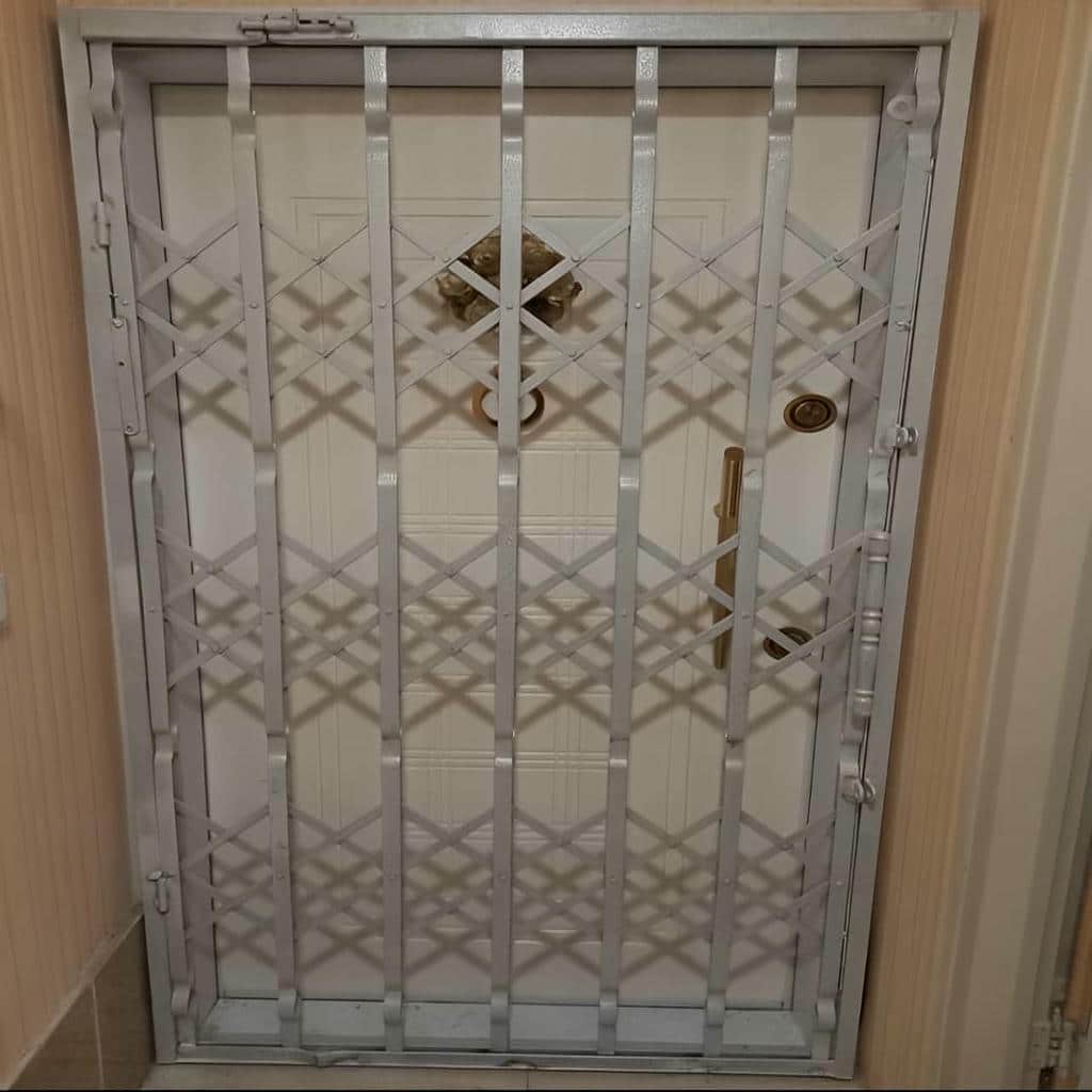 درب آکاردئونی آپارتمان سفید نصب شده روی ورودی