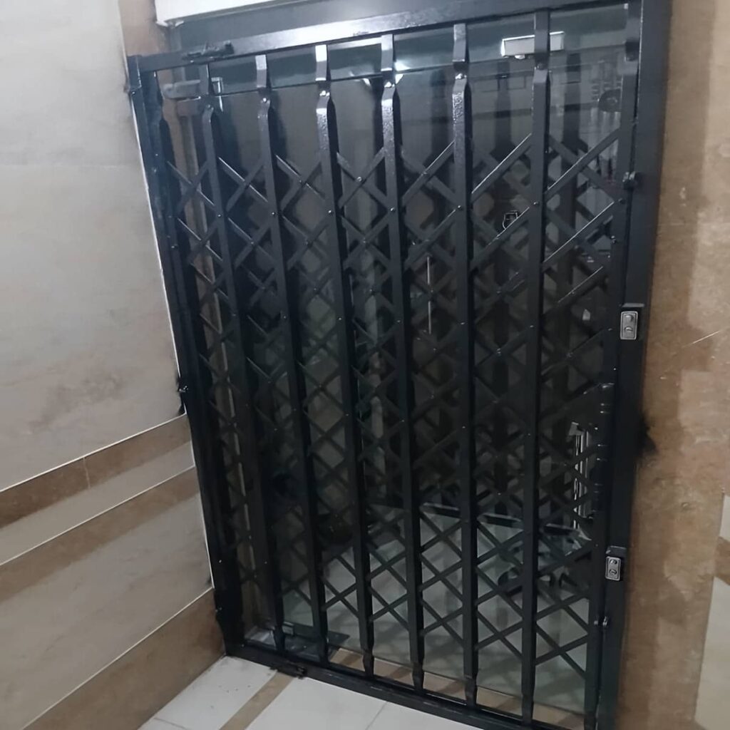 درب آکاردئونی جمع شده کنار ورودی ساختمان درب آکاردئونی جمع شده کنار ورودی ساختمان