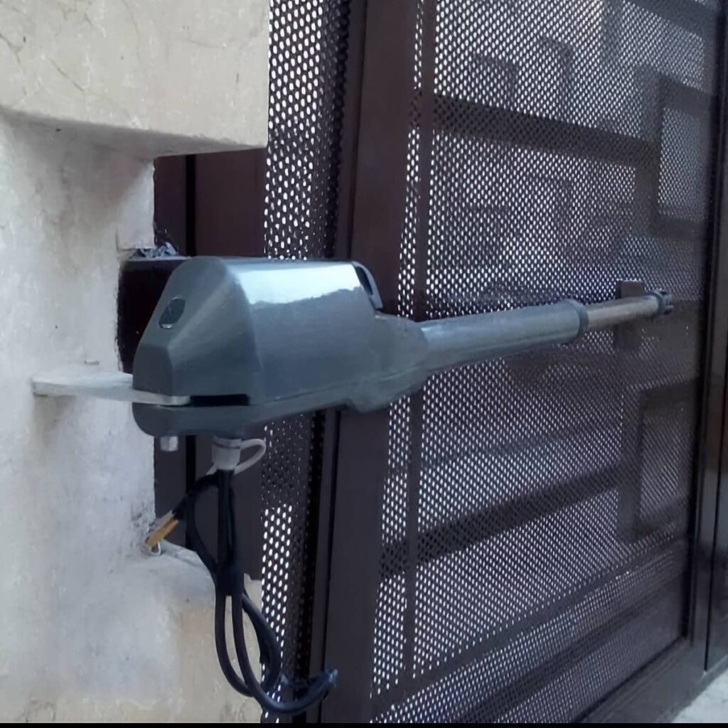بازوی فلزی دربازکن برقی روی چهارچوب ورودی