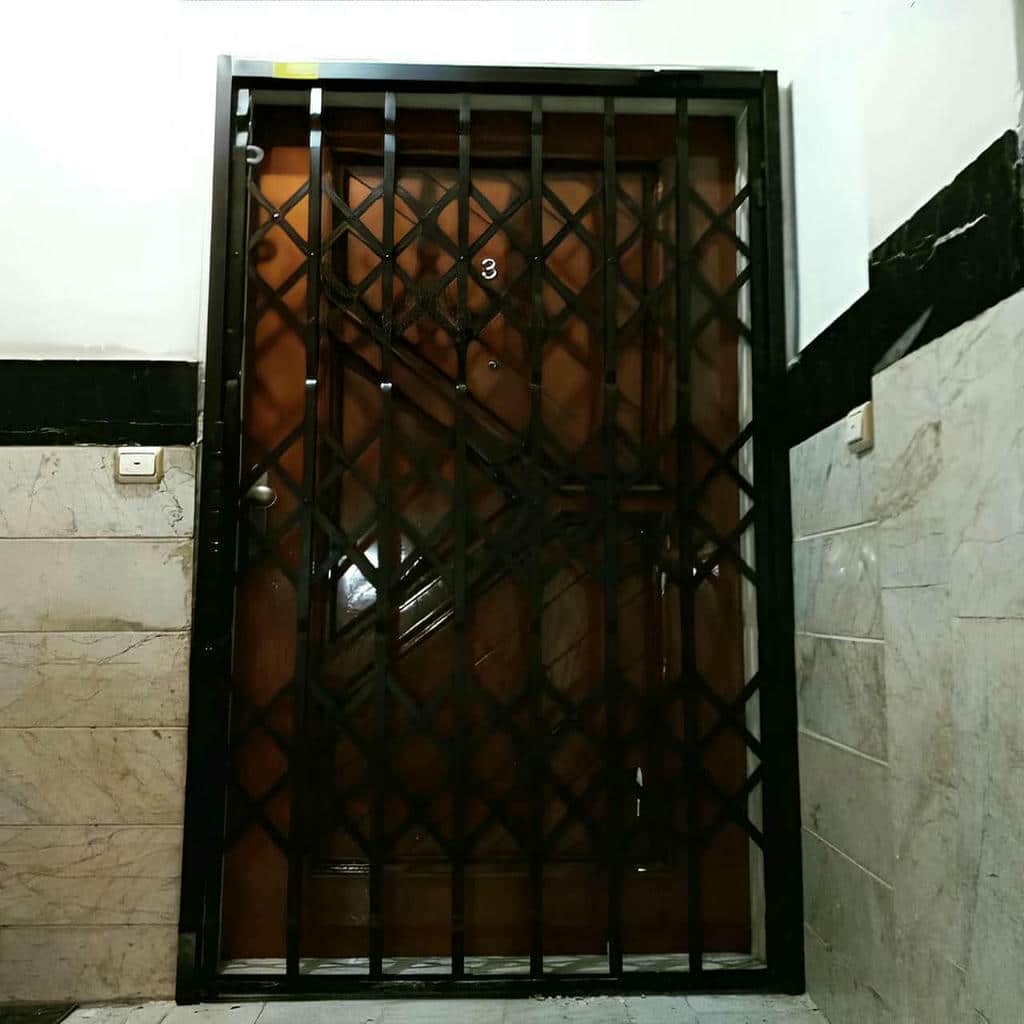 حفاظ جمع شونده فلزی کنار چهارچوب ورودی آپارتمان