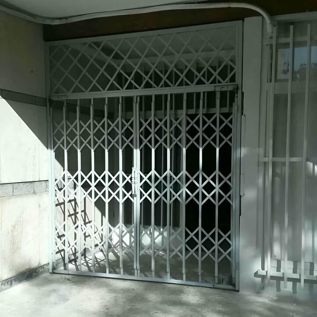 حفاظ درب آکاردئونی جمع شده کنار چهارچوب