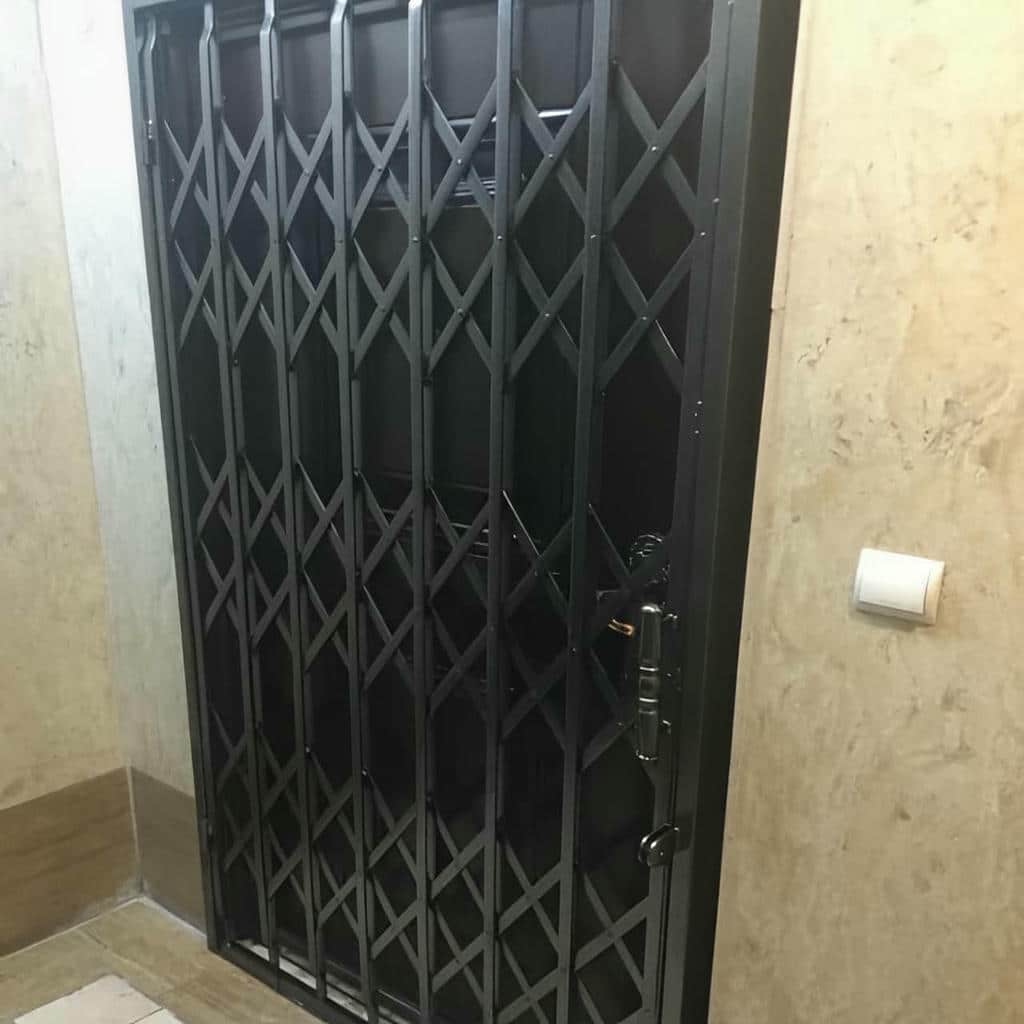 درب آکاردئونی فلزی مشکی در ورودی آپارتمان مشهد