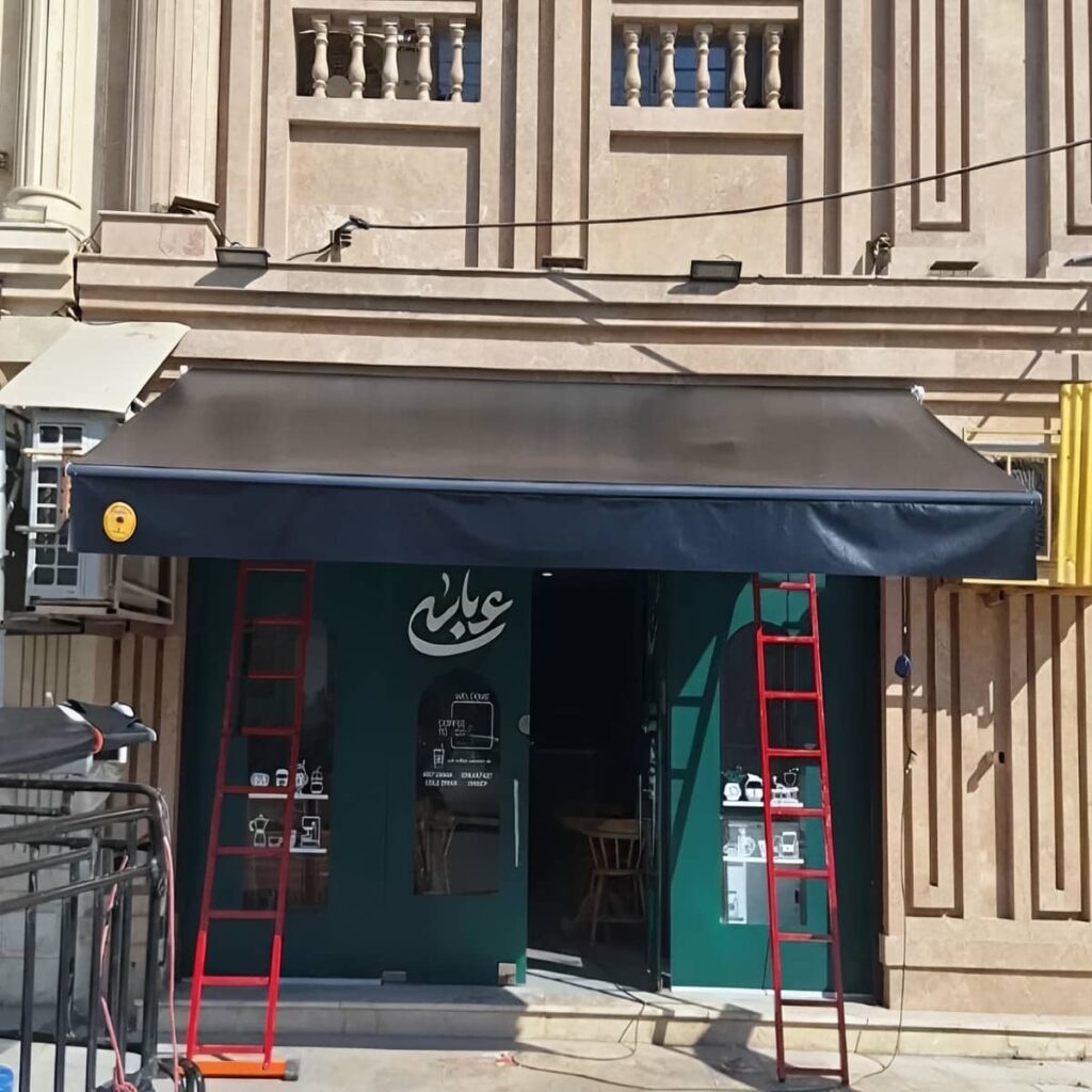 سایبان بازویی با پارچه کرم روی تراس