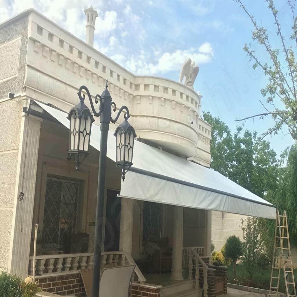 سایبان برقی در استان کرمانشاه با پارچه کرم و بازوی فلزی